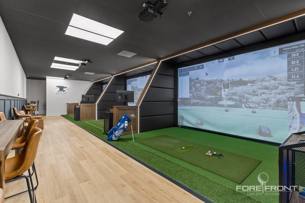 A wide simulator lounge with a wood floor, angled bays and a dining table alongside.